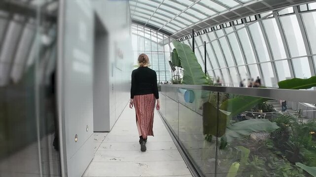 Woman walking in a beautiful rooftop botanic garden building