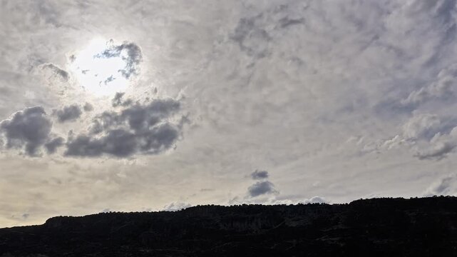 4K drone timelapse captures dreamlike silver grey clouds sweeping over a rugged southwest canyon edge. Cinematic ethereal skyscape, high altitude geography, and shifting natural light textures.