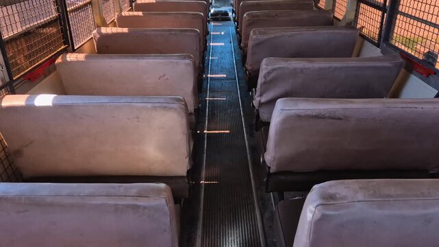 Inside view of seats in a prison bus Blue Bird of M.S.D.O.J. with bars on the windows, back view