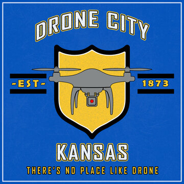 Humorous promotion for fictitous town, Drone City. Logo is yellow shield with gray drone silhouette on a blue background. Whimsical catch-phrase is There's No Place Like Drone!