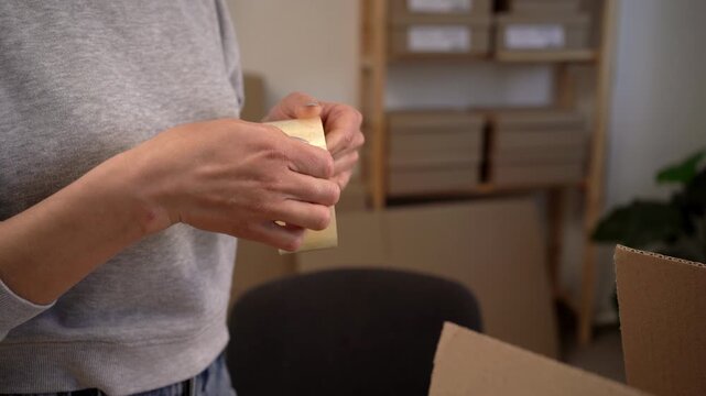 Female hands unpack adhesive tape indoors