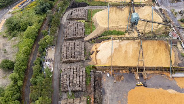 Aerial view of the Biofabrica de Ence with large piles of wood chips and stacked timber logs in Pontevedra, Pontevedra, Spain.