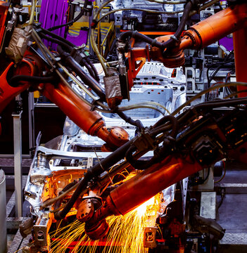 Automated robotic arms are welding on the car body production line.