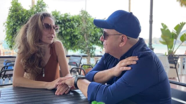 Pareja conversando en una mesa con las manos entrelazadas