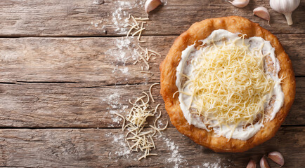 Fototapeta premium Lángos ungherese con panna acida e formaggio su tavolo rustico. Generative AI 