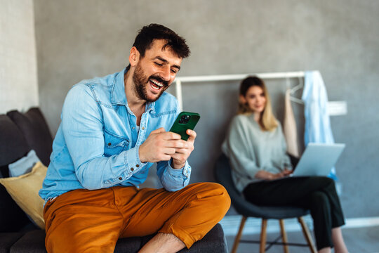 Man enjoys digital lifestyle at home, using smartphone for online connection, mobile communication
