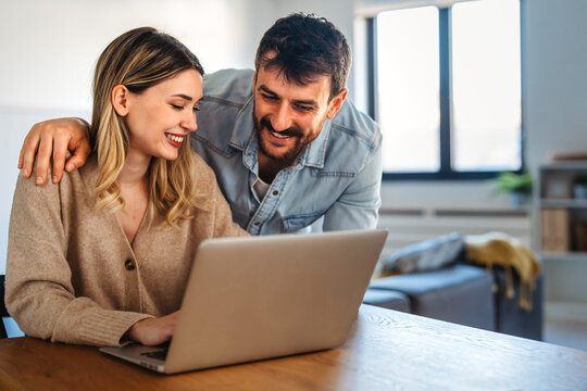 Multicultural couple working remotely, planning finances and investments online. Digital lifestyle