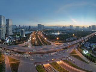 Blue hour aerial panorama of illuminated Thang Long Boulevard and Hanoi skyline with light trails from evening traffic. © Hanoi Photography