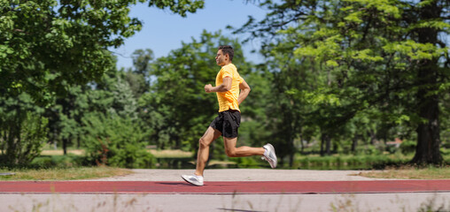 Obraz premium Athletic man jogging on a running track