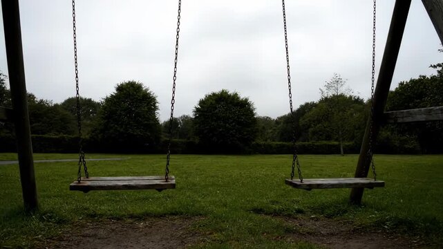 Empty Swing Set in a Quiet Park on a Cloudy Day.