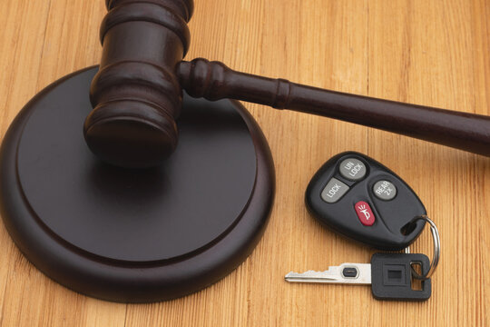 Judge gavel and block on wood desk with car keys