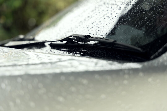 car windshield with rain drops and wiper during rainy weather