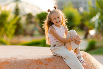 Naklejka premium little happy girl at a playground in the city in summer