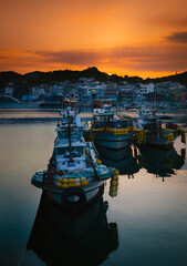 Fototapeta premium Sunset seascape with moored fishing boats at the Gangguan Port in Tongyeong‑si, Gyeongsangnam‑do, South Korea