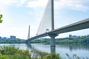 Fototapeta premium Guri-Topyeong Bridge and a peaceful riverside walking path along the Han River in Guri, South Korea
