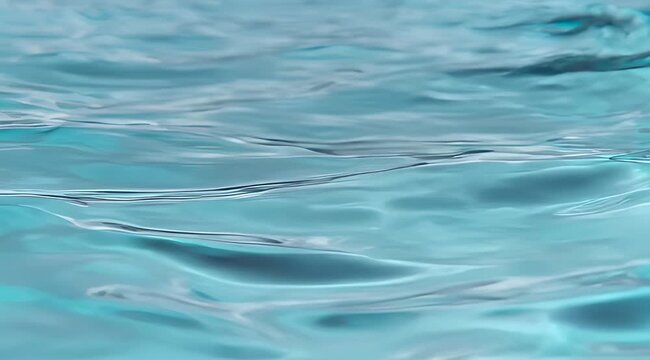 Calm blue water surface with serene ripples creating abstract light reflections