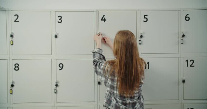 Schoolgirl opening numbered locker at school