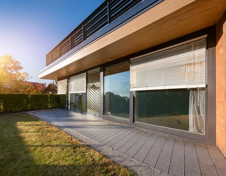 visual featuring roller blinds installed on a panoramic window of a modern house the external shutters are shown providing sun protection and privacy for the exterior of the home