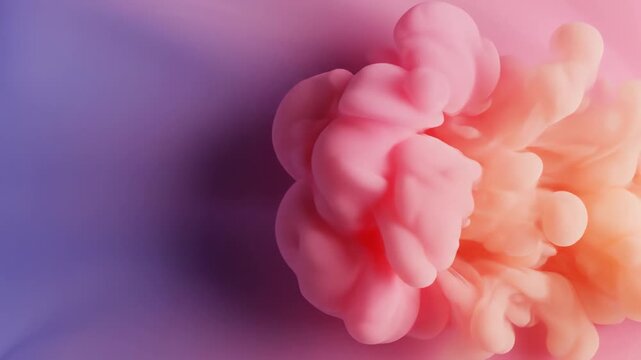 Vibrant swirling clouds of pink and orange liquid pigment dissolve and merge dramatically across a soft gradient of blue and purple, creating an abstract artistic expression of form and fluidity