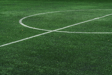 Obraz premium high-angle shot of lush green artificial turf featuring white painted lines, perfect for sports backgrounds, football fields, and athletic themes.