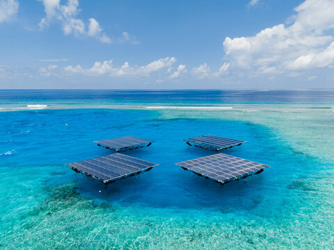 Aerial view of SolarSea floating solar power plant by Swimsol on turquoise lagoon waters with coral reefs and a clear blue sky Dharavandhoo, Baa Atoll, Maldives.