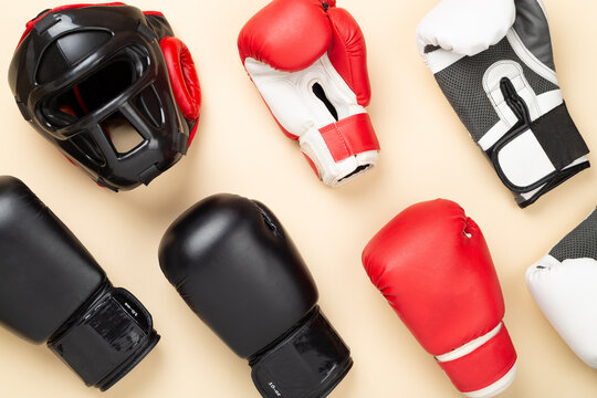 Boxing helmet and gloves on color background, top view.