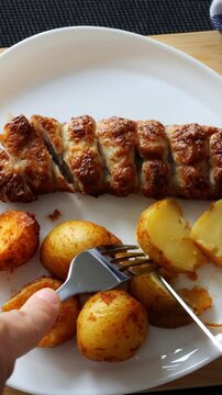 Toronto, Canada, January 12, 2026: Closeup taster cutting potato revealing soft interior, fork lifts buttery slice next to sliced grilled meat, warm lighting emphasizes texture and mouthfeel