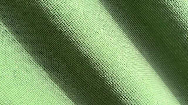 Green corrugated roof tile close-up showing weathered textured surface, subtle moss patches along ridges, sunlight casting soft