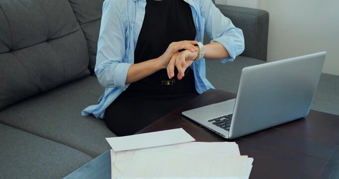 Hands check watch. Person glances at wristwatch regularly. Someone reviews schedule on wrist while working at home desk. Person takes brief moment to check time during work and break sessions