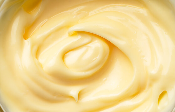 Creamy mayonnaise texture with soft swirls and glossy finish, macro top view of thick yellow sauce background