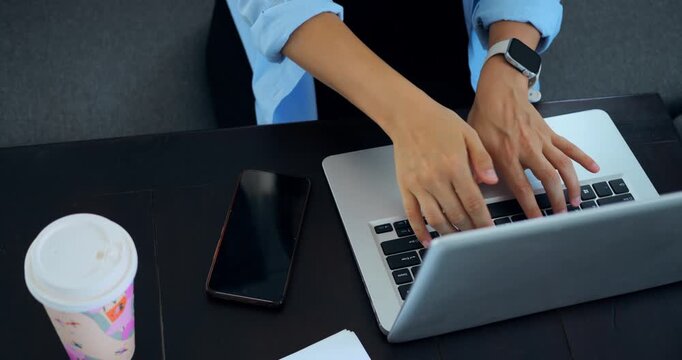 Efficient work scene. Focus on hands typing. Overhead perspective of focused typing environment. Highangle shot capturing focused hands typing amidst office accessories and modern setting
