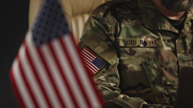 American army intelligence officer developing defense policy on laptop in office