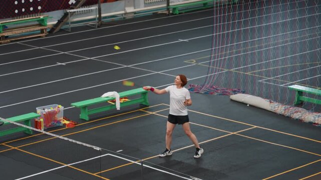 Female executing court drills carefully. Woman performing precise badminton exercises diligently. Woman concentrates on perfecting badminton techniques with careful footwork and accurate shots