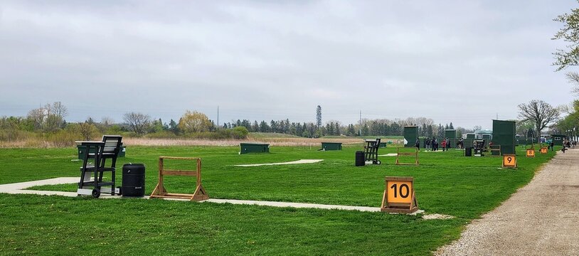 Outdoor trap shooting range with distance markers and grassy firing lanes
