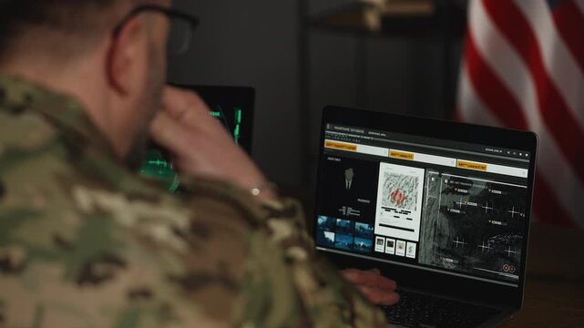 U.S. army officer collecting satellite data and planning operations on laptops