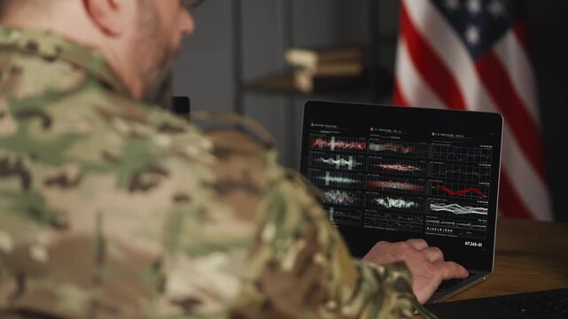 U.S. intelligence officer working on laptop, collecting data for secret mission