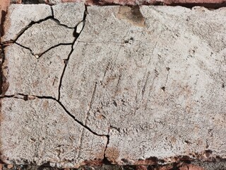Fototapeta premium Natural light stone brick with deep cracks and weathered surface texture