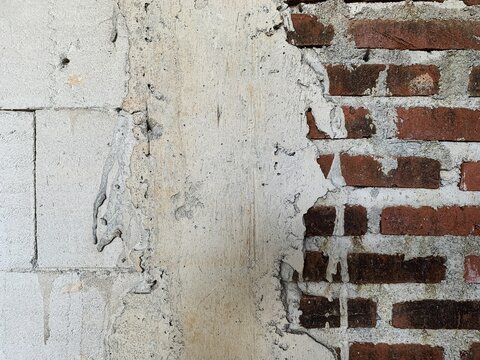Grungy unfinished wall texture with red bricks and white aerated concrete blocks. classic red clay bricks.