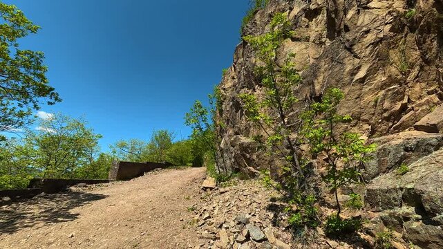 Sunlit trail winds past rocky cliffside. The Iron Gates (Djerdap Gorge), Serbia, Balkan