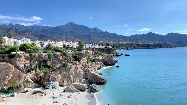Panoramic wide shot of white village Nerja on cliffs above Calahonda beach and Mediterranean sea, Summer vacation in Spain, Malaga