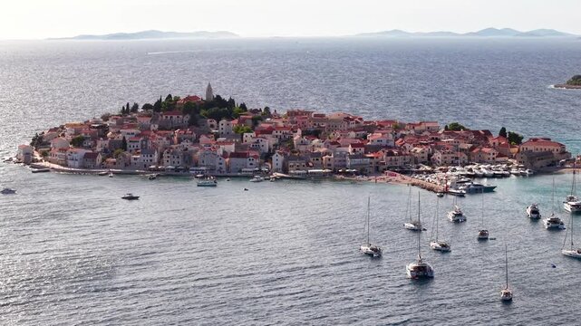 Aerial view of Primosten old town on a peninsula in Croatia, Mediterranean coastal landscape with boats in the Adriatic Sea