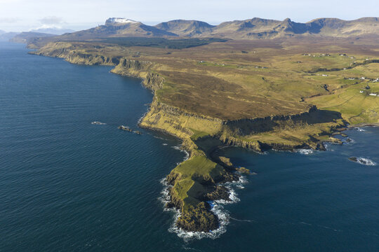 Aerial view of The Brother's Point with dramatic cliffs and the Trotternish Ridge mountains in the background in Culnacnoc, Scotland, United Kingdom.
