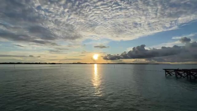 Golden Hour Ocean Timelapse Featuring Boat Silhouette and Moving Clouds