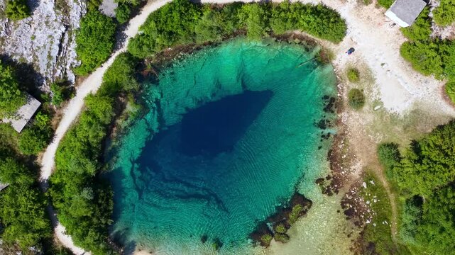 Aerial view of the Cetina River in Croatia, featuring deep blue and turquoise crystal clear water