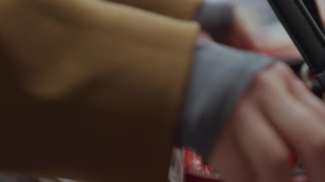 Closeup hand places purse on red shopping basket, shallow depth of field and bokeh background, stacked plastic baskets and textured handle, shopper motion in checkout aisle, retail atmosphere