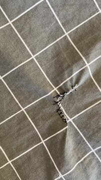 Torn Gray Fabric With Visible Stitching Damage and Ripped Seam Creating Realistic Textile Repair and Wear Detail Footage Close Up