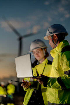 Green collar workforce using advanced tech to manage sustainable wind power. Visionary engineers committed to global ESG goals and carbon neutrality.