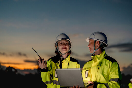 Leading global sustainability. Environmental specialists managing wind turbine grid expansion at dusk. Committed to carbon neutrality and green innovation.