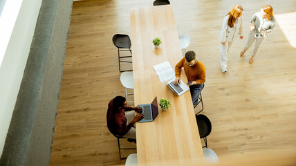 Fototapeta na wymiar People work and walk in a shared office space during the day