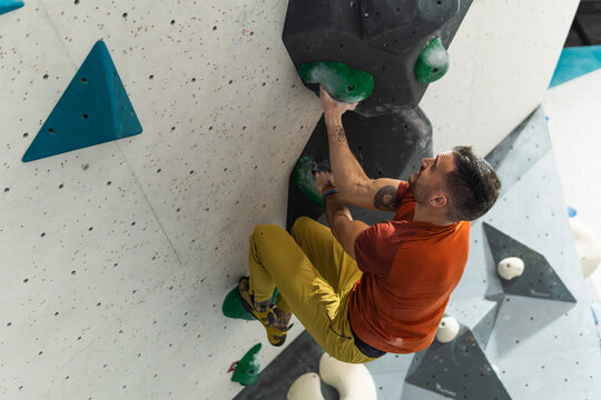 Man bouldering indoors training strength and fitness